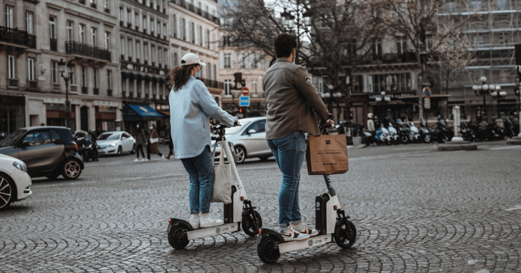 Tourists on electric scooters in a city. How can attraction sites contribute to sustainable tourism featured photo